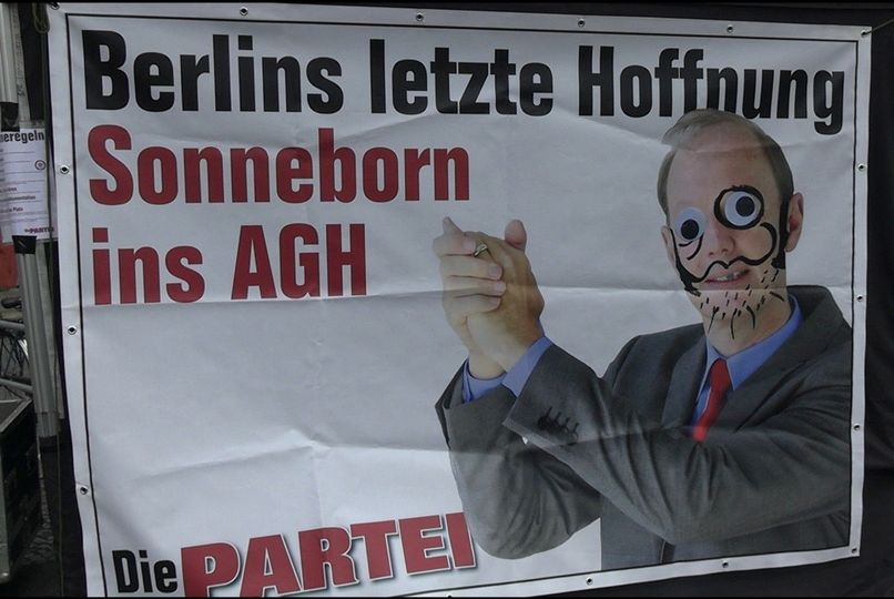 Bild eines PARTEI-Banners mit dem Text "Berlin letzte Hoffnung. Sonneborn ins AGH" und einem Foto von Martin Sonneborn mit Wackelaugen und aufgemalten Bart. 