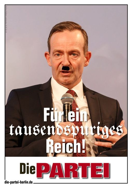 Zu sehen ist ein Die PARTEI-Plakat mit einem Bild von Volker Wissing mit einem aufgemalten schwarzen Balken unter der Nase und dem darunter stehendem Text: "Für ein tausendspuriges Reich".